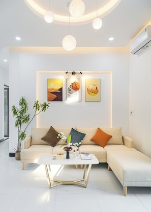 A modern living room with a sofa, coffee table, and wall art.
