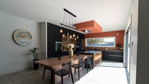 A modern kitchen with a central island, pendant lighting, and a large window. - Villa 5 minutes from the beach and Les Sables d'Olonne (Talmont-Saint-Hilaire)