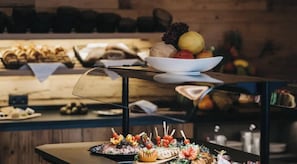 Un buffet proposant une variété de plats et un saladier rempli de fruits.