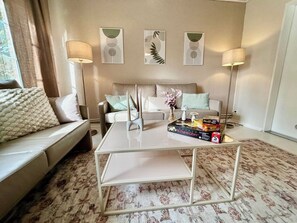 A living room with a sofa, a coffee table, and three wall-mounted lamps. - Large vacation home near Kiel - 5 SZ - Garden - WLAN - Parking lot (Kiel)