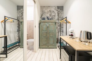 Ein Badezimmer mit einem Holzkosmetikschrank, einem Spiegel, einem Handtuchhalter, einem Waschbecken und einer Toilette.