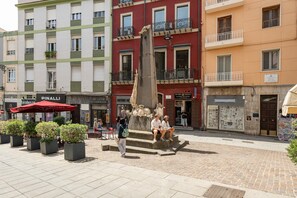 A public square with a central monument, surrounding buildings with shops, and outdoor seating. - Suite Saint Remy Villanova Room with Wi-Fi and Air Conditioning (Cagliari)