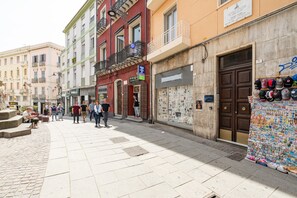 Vista de una calle con edificios, una acera y una tienda de sombreros.