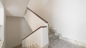 Una scala con pareti bianche e gradini in marmo.