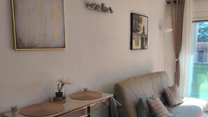 A living area with a sofa, a coffee table, and a small bar area with stools. - SEASIDE STUDIO (Calcatoggio)