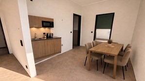 Une cuisine moderne équipée d’un four à micro-ondes, de meubles en bois et d’un coin repas avec une table et des chaises.