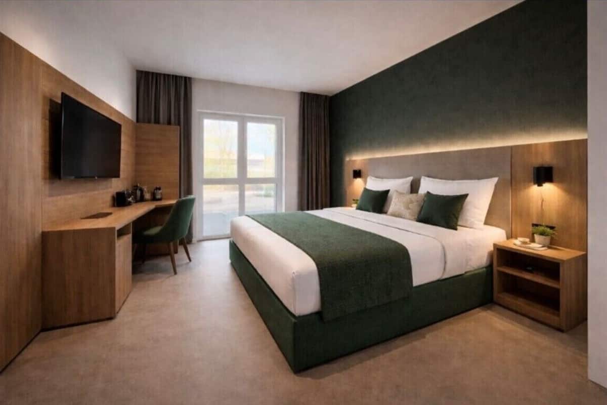 A modern hotel room with a bed, a desk, a flat-screen TV, and a large window.