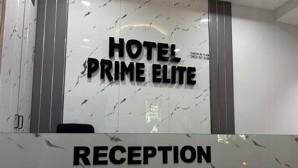 A reception area with a marble wall and a sign that reads 'HOTEL PRIME ELITE.' - Hotel Prime Elite (Ahmedabad)