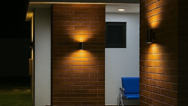 Een modern gebouw aan de buitenkant met bakstenen muren, een blauwe stoel en twee wandlampen.