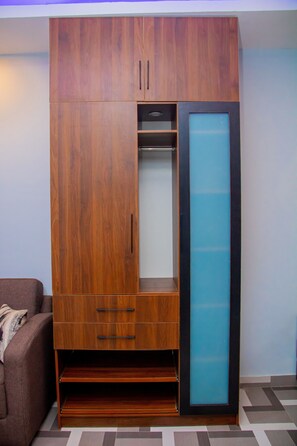 Un armario de madera con puerta corredera, un estante y un cajón.