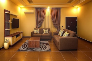 A living room with a sofa, a coffee table, a TV, and a cabinet.