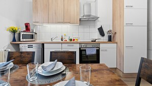 Une cuisine moderne avec des meubles en bois, un four à micro-ondes, une cuisinière et un lave-vaisselle.
