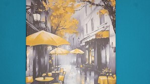 Un tableau représentant une rue pluvieuse, avec des tables, des chaises, des parapluies et des bâtiments.