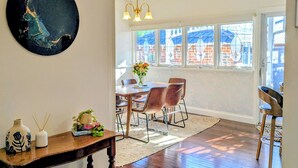 A dining area with a wooden table, chairs, and a chandelier.
