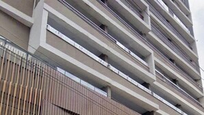 Een meerlaags gebouw met een modern ontwerp, voorzien van balkons en een gevel met verticale houten lamellen.