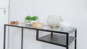 A glass-top table with a wooden box, a potted plant, and a white vase against a white wall. - fewo1846 - Strandkoje / luxurious old apartment for max 5 persons with sea view (Flensburg)