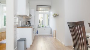 A modern kitchen with white cabinetry, a wooden floor, and a window with a view. - fewo1846 - Strandkoje / luxurious old apartment for max 5 persons with sea view (Flensburg)