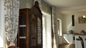 Quarto com um armário de madeira, uma cadeira e uma mesa com um cesto de flores.
