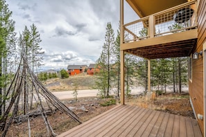A wooden deck, a view of a building with a balcony, and a forested area. - NEW! Ski-In/Out Granby Ranch・Sleeps 16 ・Arcade (Granby)
