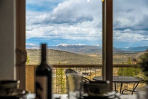A room with a view of snow-capped mountains, a table, and a chair. - NEW! Ski-In/Out Granby Ranch・Sleeps 16 ・Arcade (Granby)