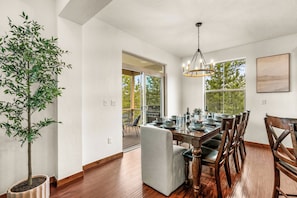 A dining area with a wooden table, chairs, a chandelier, and a potted plant. - NEW! Ski-In/Out Granby Ranch・Sleeps 16 ・Arcade (Granby)
