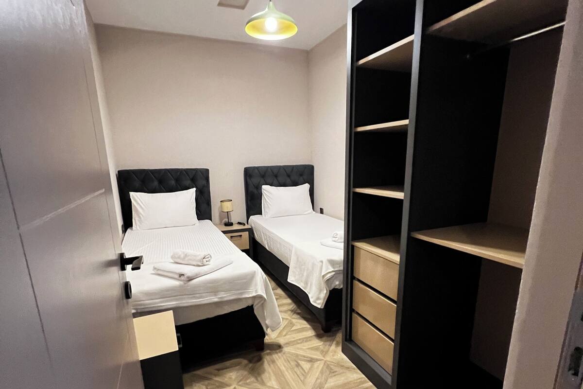 A hotel room with two beds, a walk-in closet, and a geometric patterned floor.