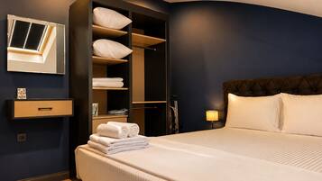 Een hotelkamer met een bed, een inbouwkast, een spiegel en een nachtkastje.