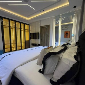 A modern hotel room with a large bed, a TV, and a sliding glass door. - CHINBELL LUXURY HOTEL & SUITES  (Lekki)