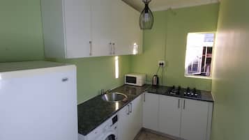 Full-sized fridge, microwave, stovetop, cookware/dishes/utensils