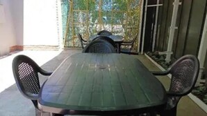 An outdoor patio with a green table and four chairs.
