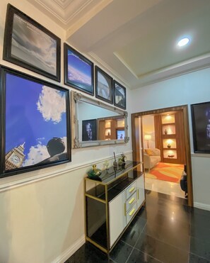 A modern living room with a glass coffee table, a sofa, and a TV. - THE H ADDRESS (Lagos)
