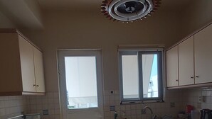 Eine Küche mit Schränken, einem Herd, einer Spüle und einem Fenster.