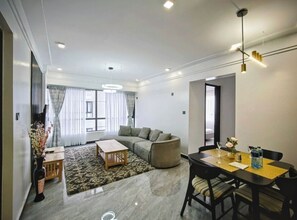 Ein modernes Wohnzimmer mit Sofa, Couchtisch und Essbereich mit Stühlen und Tisch.