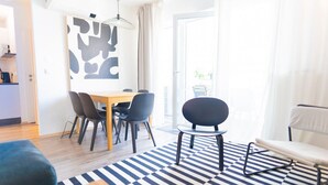A modern living room with a dining area, a checkered floor, and a large window. - White and black by Prater #40 (Vienna)