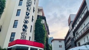 Een hotel met meerdere verdiepingen, met een opvallende gevel die een verticaal zwart-wit patroon heeft.