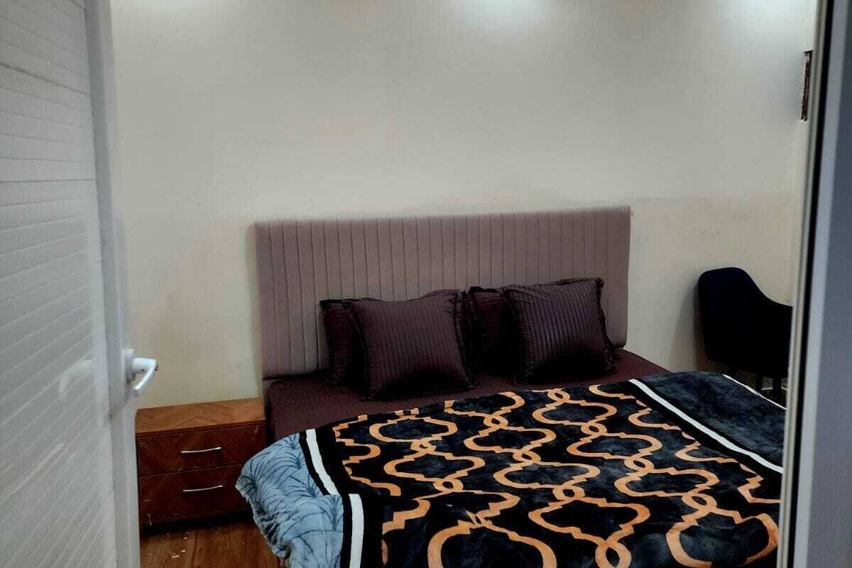 Un dormitorio con una cama, ventilador de techo y suelo de madera.