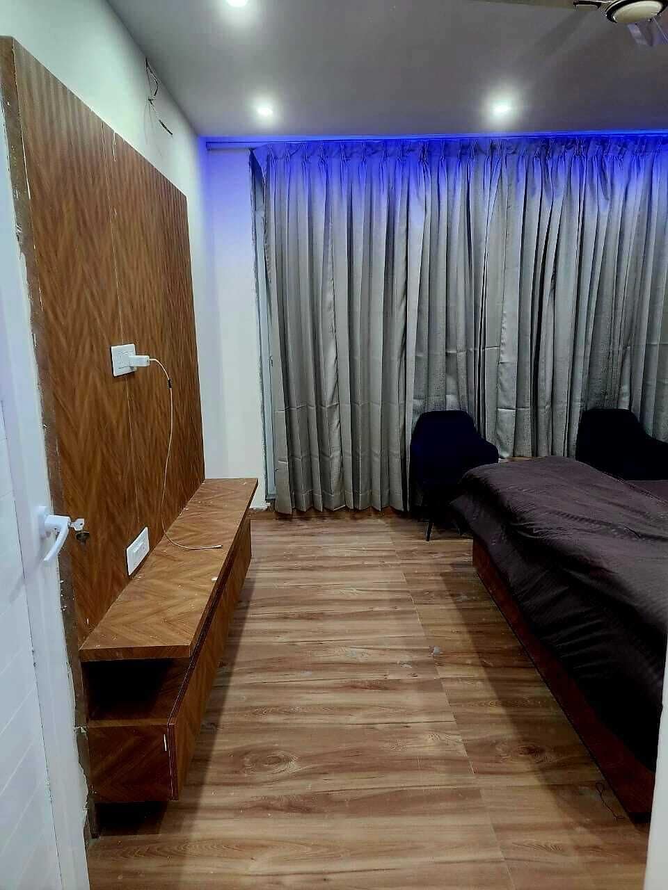 A bedroom with a wooden bench, a bed, a chair, and a curtain.