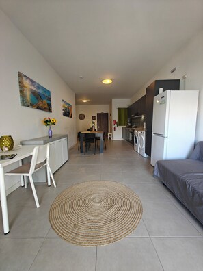 A modern apartment with a dining area, kitchen, and living space.