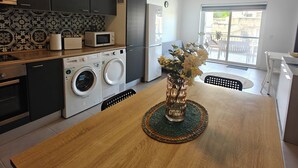 Eine moderne Küche mit Waschmaschine, Mikrowelle und Kühlschrank.
