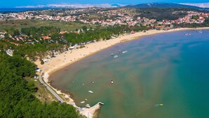 Luftaufnahme einer Küstenstadt mit Strand, Booten und Gebäuden.