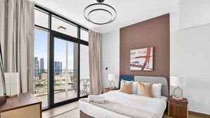 Une chambre d’hôtel moderne avec un grand lit, deux tables de chevet, une vue sur le paysage urbain et une grande fenêtre avec des rideaux.