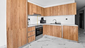 Une cuisine moderne avec des meubles de rangement en bois, un four encastré, un four à micro-ondes et un évier.