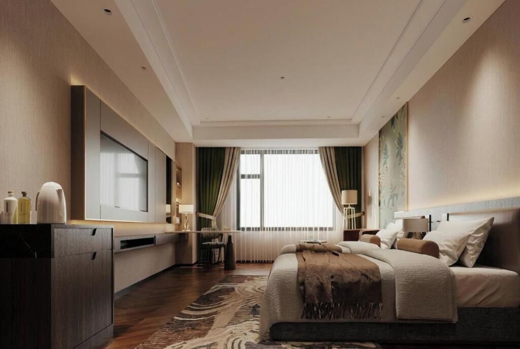 A modern hotel room with a large bed, a flat-screen TV, a desk, and a window with curtains.