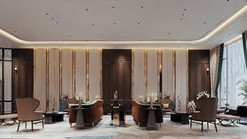 Een moderne hotellobby met een centrale zithoek, grote ramen en decoratieve panelen.