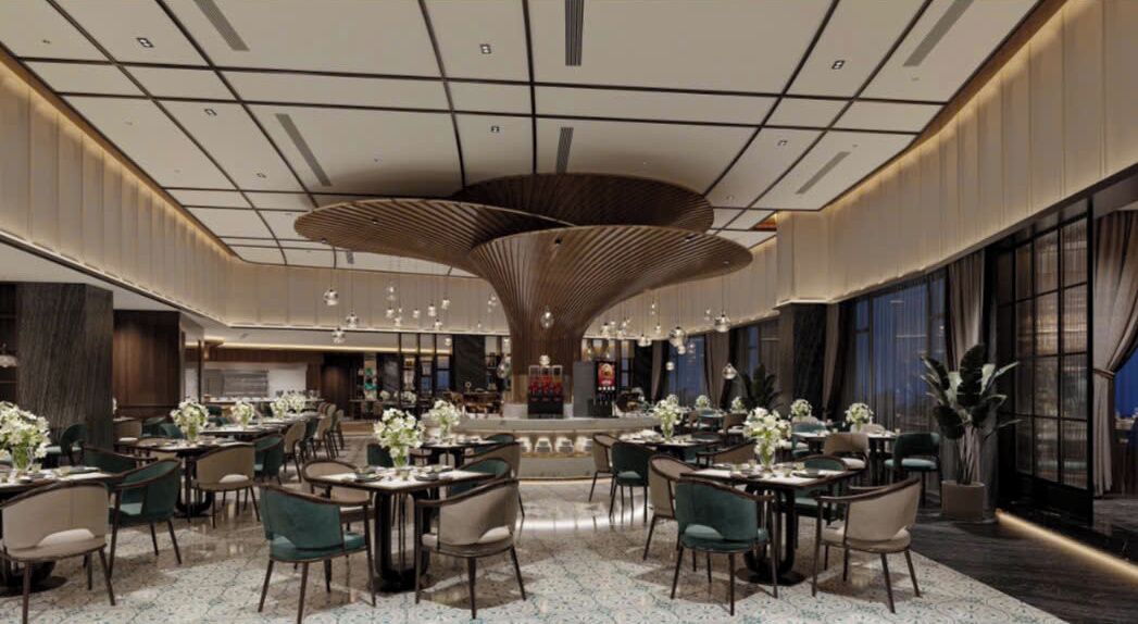 A spacious hotel lobby with a central bar area, multiple seating arrangements, and a modern ceiling design.