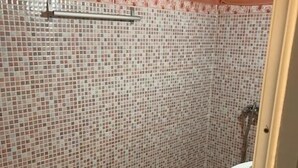 A bathroom with a tiled wall, a toilet, and a sink. - Hôtel Restaurant ASGAOUR (Asgaour)