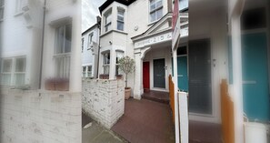 A residential building with a brick facade, a red door, and a blue door. - Refined 2BD Home in Fulham (London)