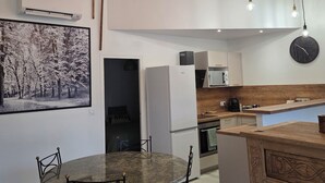 A modern kitchen with a central island, a dining area with a round table and chairs, and pendant lighting. - Villa ma sueur - house with a story. (Coutras)