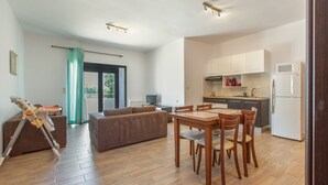 A modern apartment with a dining area, kitchen, and living room.