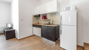 A modern kitchen with white cabinets, a microwave, a refrigerator, and a dishwasher.